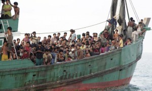 Migrants sit on a boat as they wait to be rescued by Acehnese fishermen on the sea off East Aceh, Indonesia. Photograph: S. Yulinnas/AP